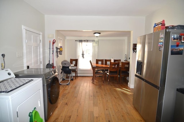 clothes washing area with separate washer and dryer and light hardwood / wood-style flooring