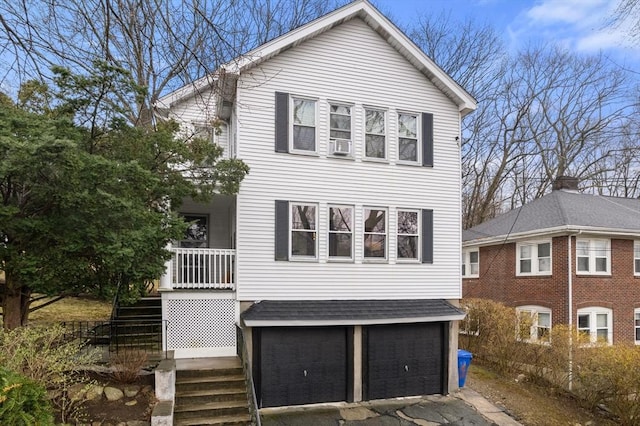 65-67 Westchester Rd, Newton, MA 02458 - view of front of home featuring a garage, stairs, aphalt driveway, and a shingled roof