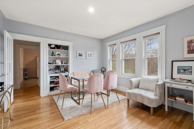 65-67 Westchester Rd, Newton, MA 02458 - dining area featuring light wood-type flooring, baseboards, and radiator