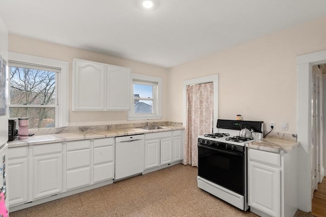 65-67 Westchester Rd, Newton, MA 02458 - kitchen with white cabinets, white dishwasher, gas range, a sink, and light countertops