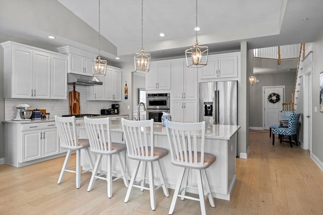 kitchen featuring stainless steel appliances, white cabinetry, and backsplash