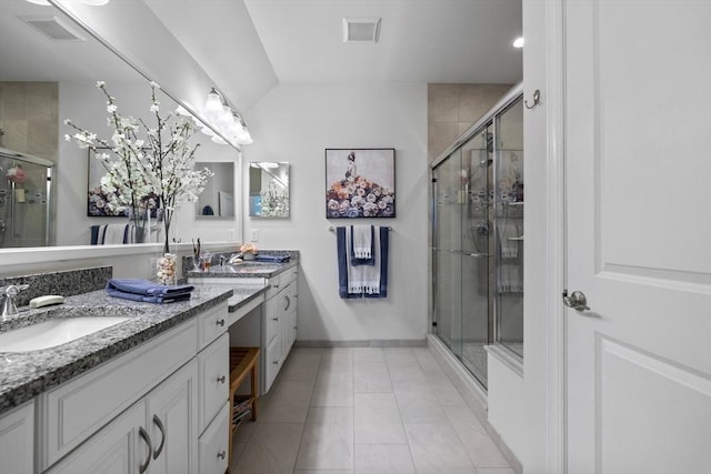 bathroom featuring a stall shower, visible vents, a sink, and double vanity