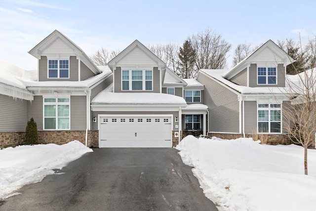 craftsman inspired home featuring a garage and aphalt driveway