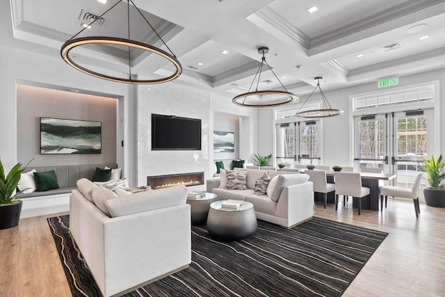 living room with a premium fireplace, wood finished floors, visible vents, french doors, and crown molding