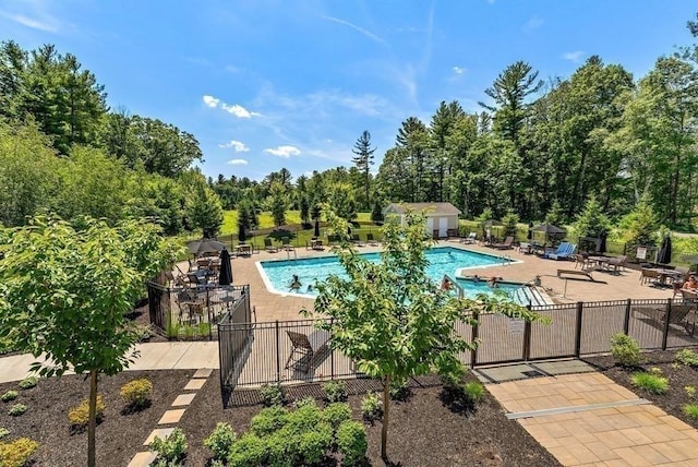 community pool with a patio area and fence