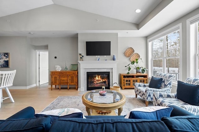 living area with recessed lighting, a fireplace, baseboards, vaulted ceiling, and light wood-type flooring