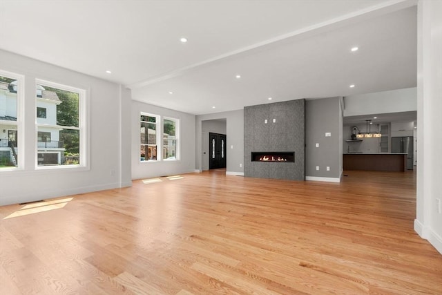 unfurnished living room with a fireplace and light hardwood / wood-style flooring