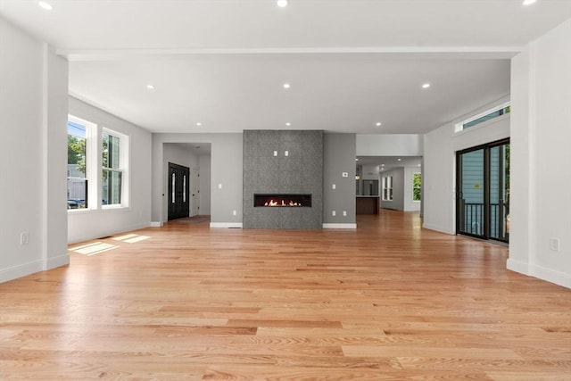 unfurnished living room with a fireplace and light wood-type flooring