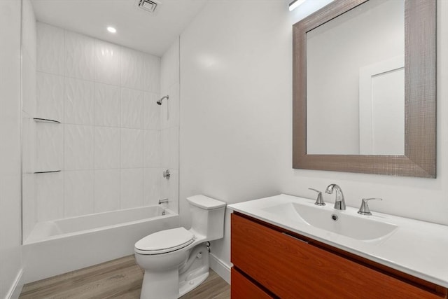 full bathroom with tiled shower / bath, hardwood / wood-style floors, vanity, and toilet