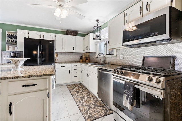 kitchen with light stone countertops, sink, white cabinets, and stainless steel appliances