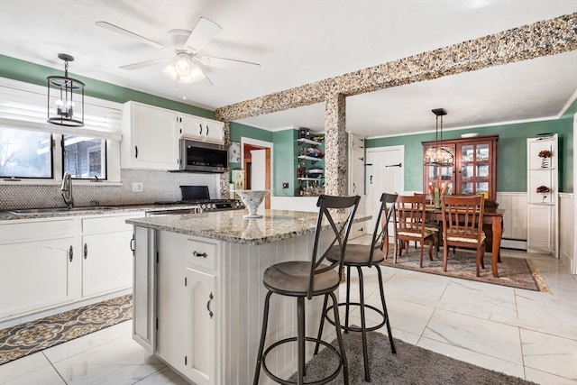 kitchen featuring white cabinetry, hanging light fixtures, stainless steel appliances, and sink