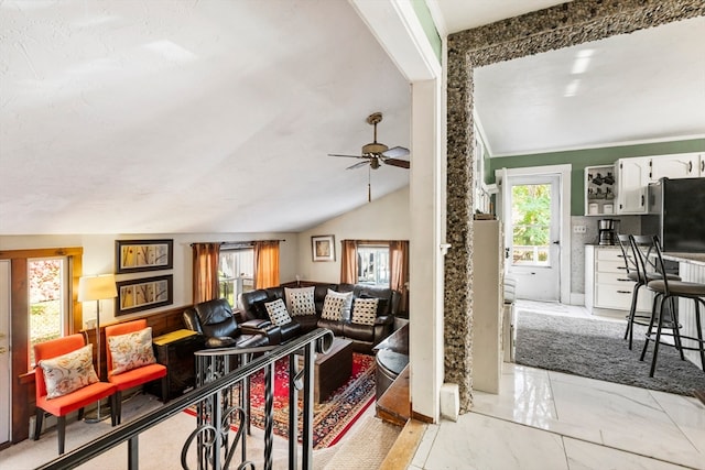 living room featuring lofted ceiling, a healthy amount of sunlight, and ceiling fan