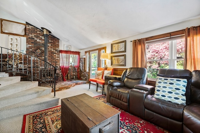 carpeted living room featuring high vaulted ceiling and a wood stove