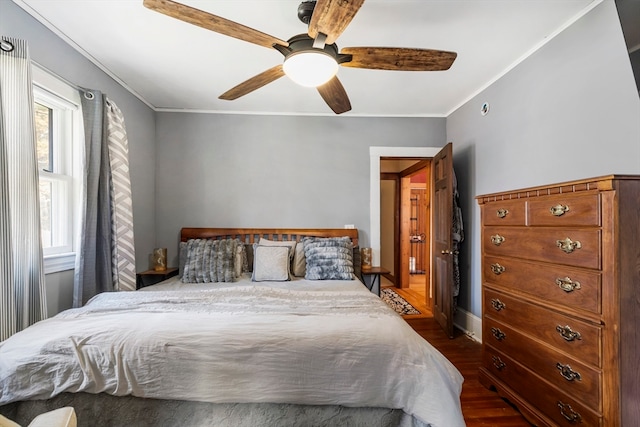 bedroom featuring ornamental molding, dark wood-type flooring, and ceiling fan