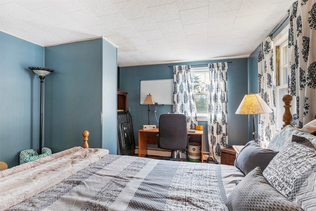 bedroom featuring crown molding and a baseboard heating unit