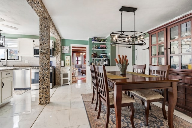 dining space with ceiling fan and sink