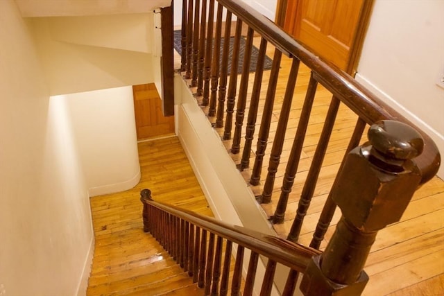 stairway with wood-type flooring and baseboards