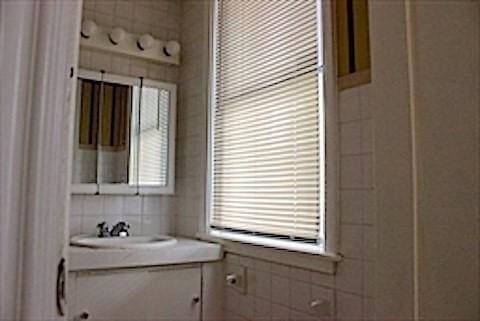 bathroom featuring tile walls and vanity