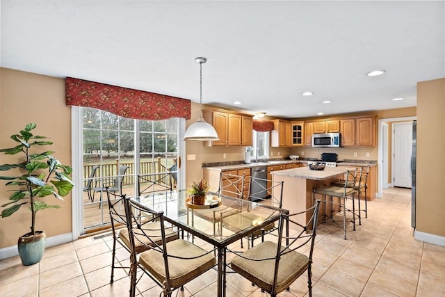 tiled dining room with a healthy amount of sunlight and sink