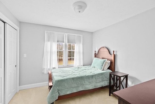 bedroom featuring light colored carpet and a closet