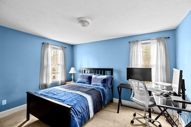 bedroom with light colored carpet and multiple windows