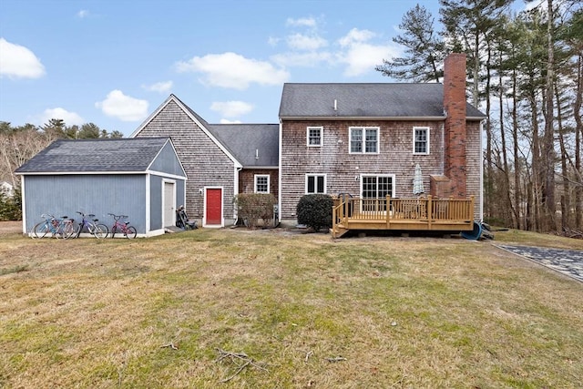 back of house featuring a wooden deck, a yard, and an outbuilding