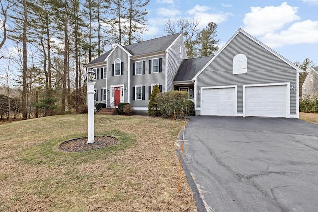 colonial-style house featuring a front lawn and a garage