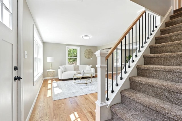 staircase featuring baseboards and wood finished floors