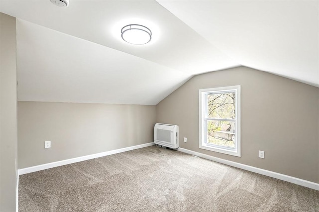 bonus room with carpet floors, baseboards, heating unit, and lofted ceiling