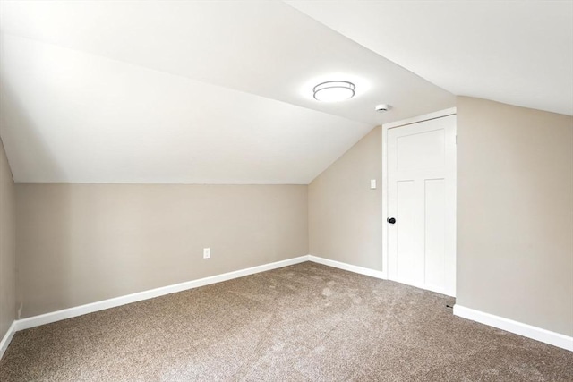 additional living space featuring carpet floors, baseboards, and lofted ceiling