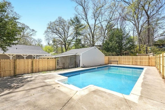 view of pool featuring a fenced in pool, an outbuilding, a fenced backyard, and a patio area