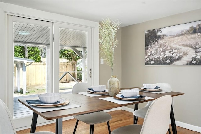 dining space with baseboards and wood finished floors