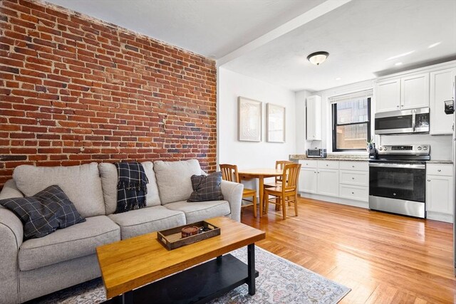 107 Jersey St Unit 16, Boston, MA 02215 - living area with brick wall and light wood-type flooring
