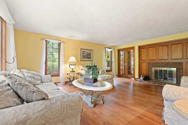 41B Washington St, Boxford, MA 01921 - living area featuring light wood-style floors, a brick fireplace, and french doors