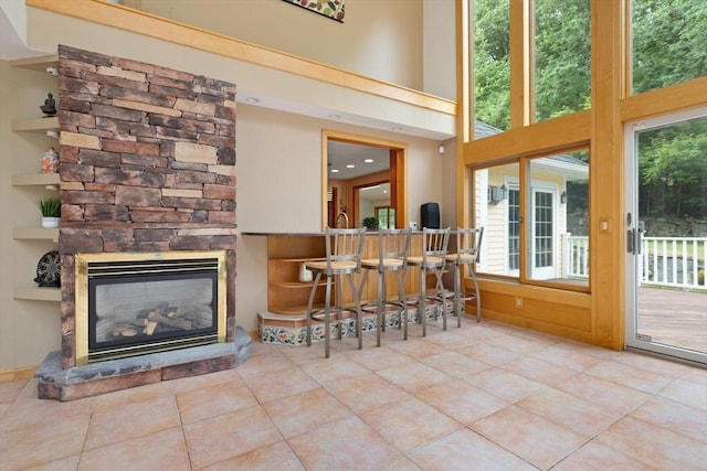 41B Washington St, Boxford, MA 01921 - living area featuring tile patterned flooring, a stone fireplace, and a high ceiling