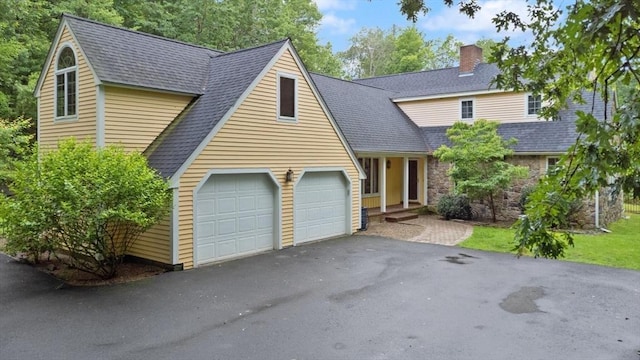 41B Washington St, Boxford, MA 01921 - view of front facade with a chimney, a garage, driveway, roof with shingles, and stone siding