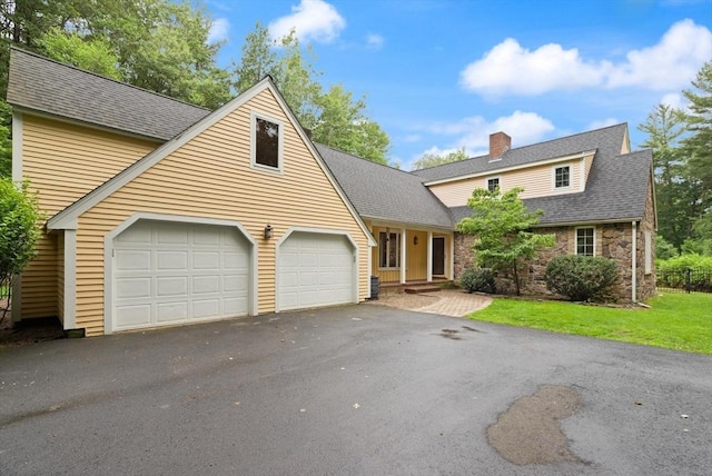 41B Washington St, Boxford, MA 01921 - view of front of house with an attached garage, a chimney, asphalt driveway, stone siding, and a shingled roof
