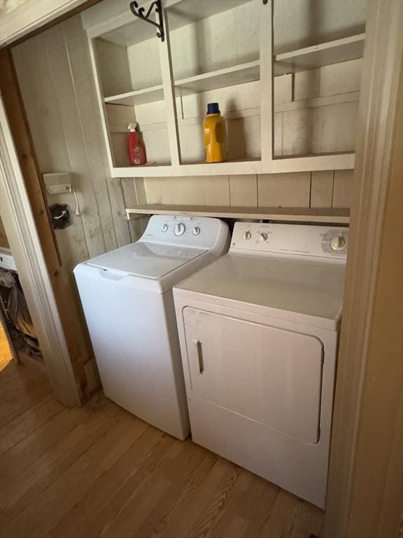 laundry area featuring laundry area, light wood-type flooring, and washing machine and clothes dryer