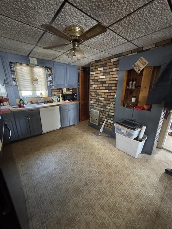 kitchen featuring brick wall, ceiling fan, dishwasher, and tile patterned floors