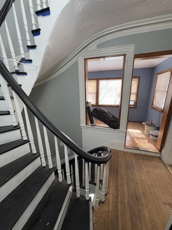 staircase with crown molding and hardwood / wood-style flooring