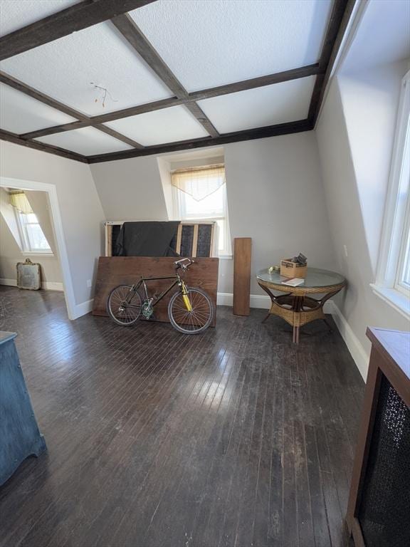 additional living space with beam ceiling, baseboards, and hardwood / wood-style floors