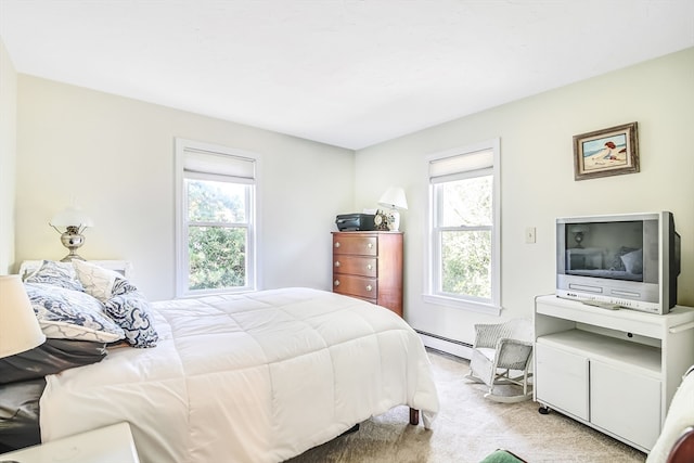 carpeted bedroom featuring a baseboard heating unit and multiple windows