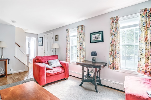 living room featuring a baseboard radiator and light hardwood / wood-style flooring