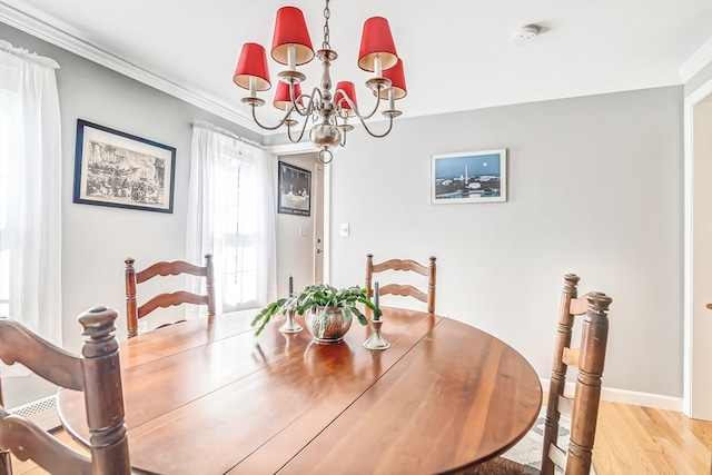 dining area with a chandelier, light hardwood / wood-style floors, and crown molding