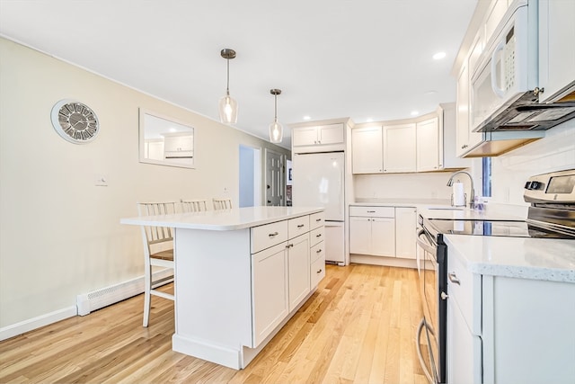 kitchen featuring white appliances, a kitchen island, decorative light fixtures, white cabinetry, and light hardwood / wood-style floors