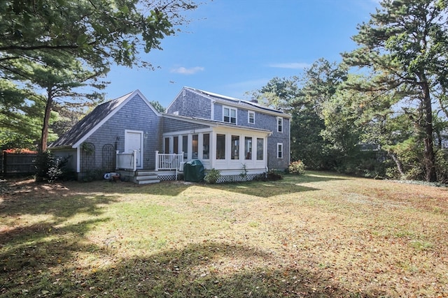 back of property featuring a sunroom and a yard