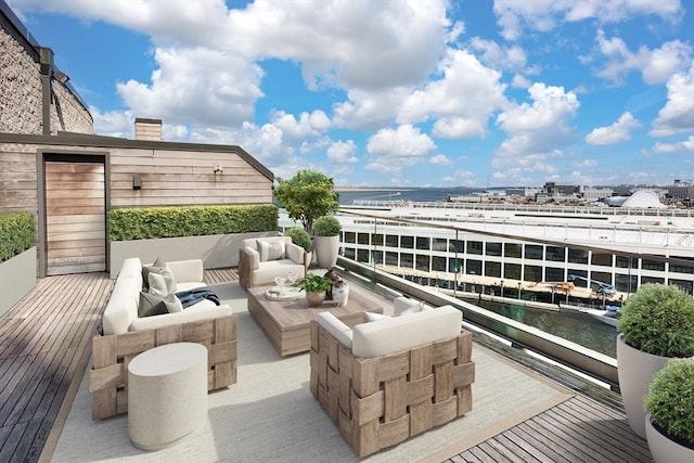 balcony with an outdoor living space and a water view