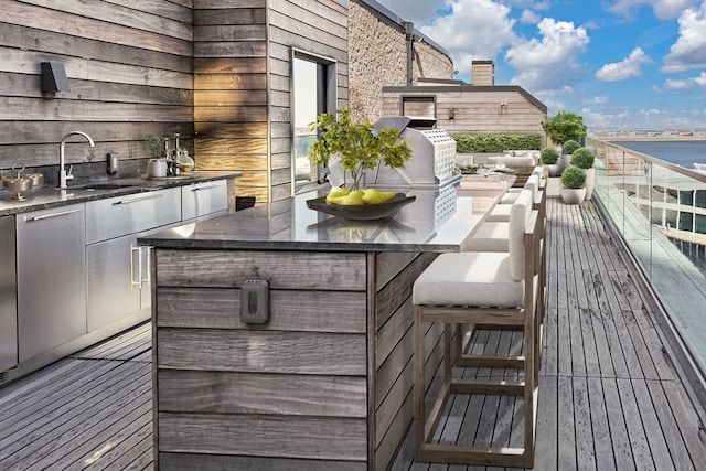 wooden terrace featuring sink and a water view