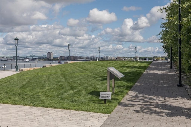 view of property's community featuring a lawn and a water view