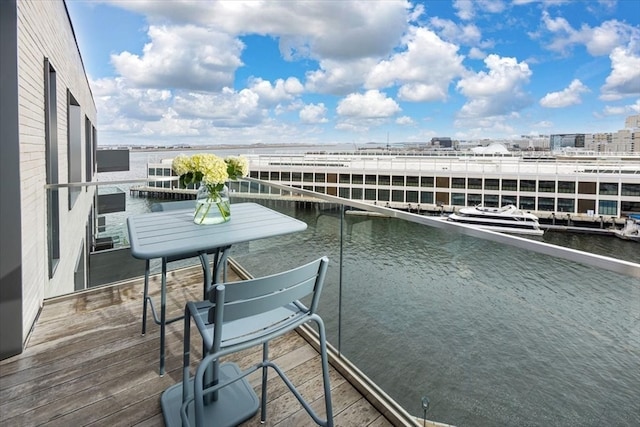 balcony with a water view and a boat dock